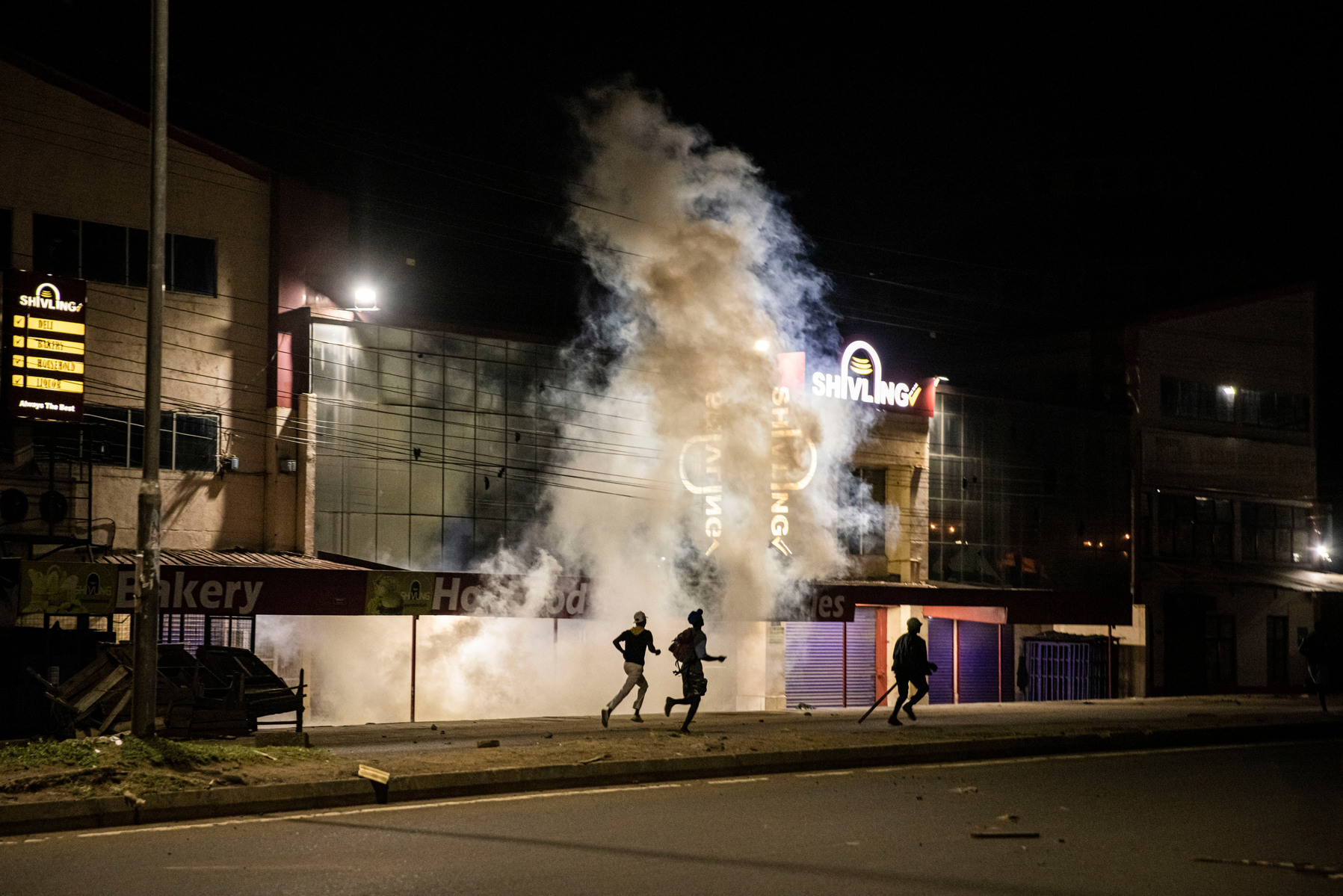 KISUMU, KENYA - AUGUST 15: People protest amid tear gas fired by Kenyan police after election results were announced on August 15, 2022 in Kisumu, Kenya. Some protesters could be heard shouting “No Raila, no peace” as they threw stones and looted shops in