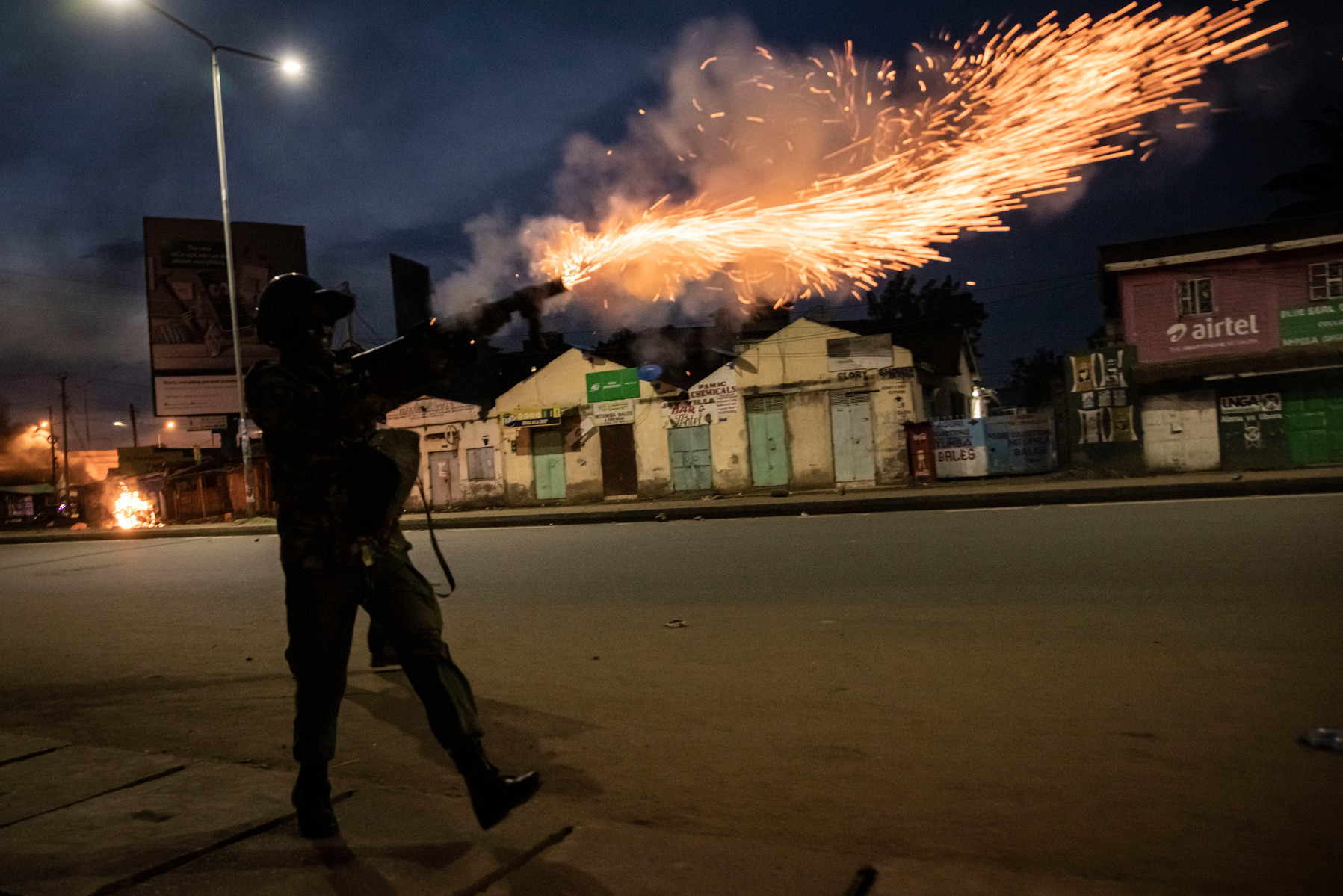 KISUMU, KENYA - AUGUST 15: Police fire tear gas as people protest after election results were announced on August 15, 2022 in Kisumu, Kenya. Some protesters could be heard shouting “No Raila, no peace” as they threw stones and looted shops in one of Raila