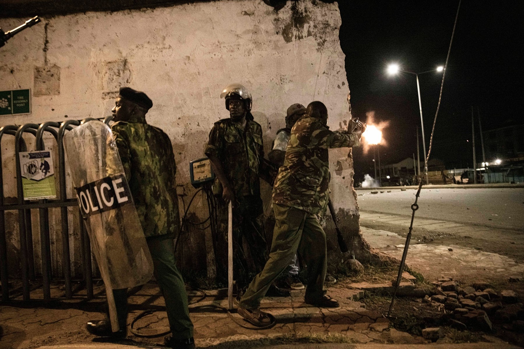 KISUMU, KENYA - AUGUST 15: Police fire tear gas and fire their rifles as people protest after election results were announced on August 15, 2022 in Kisumu, Kenya. Some protesters could be heard shouting “No Raila, no peace” as they threw stones and looted