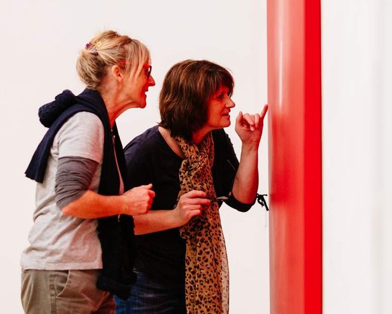 Two women looking at a painting in an art gallery in Cornwall