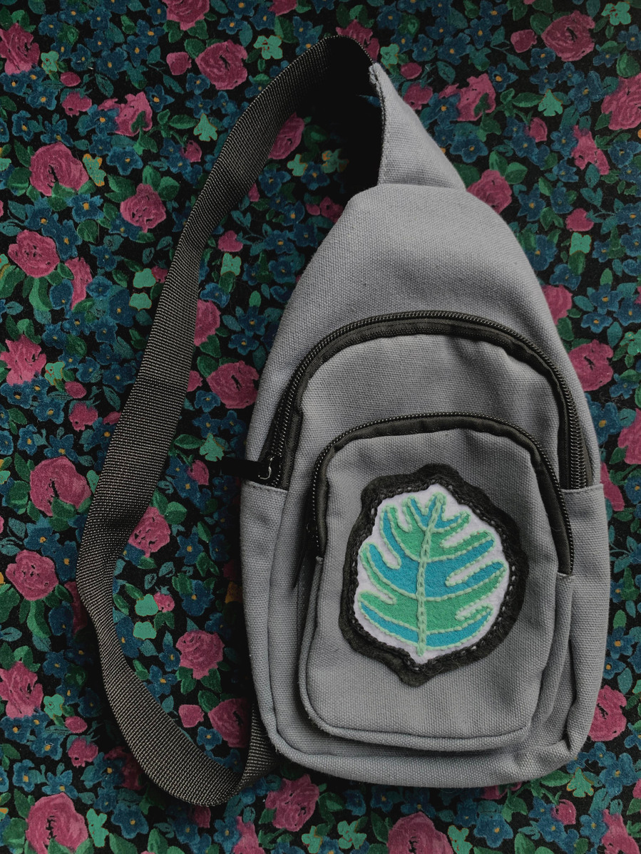 picture of an embroidered fern patch on a grey pouch