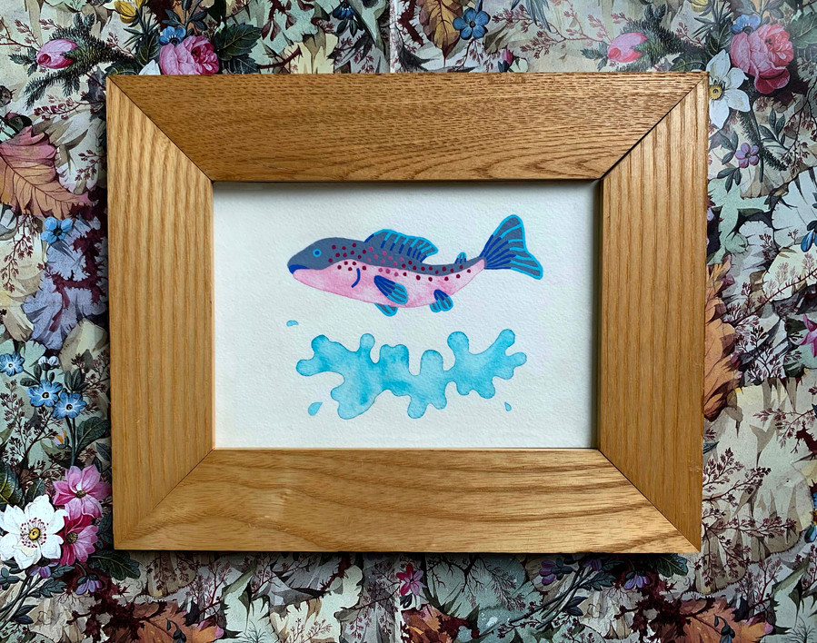 picture of a painting of a salmon inside a frame on a patterned surface