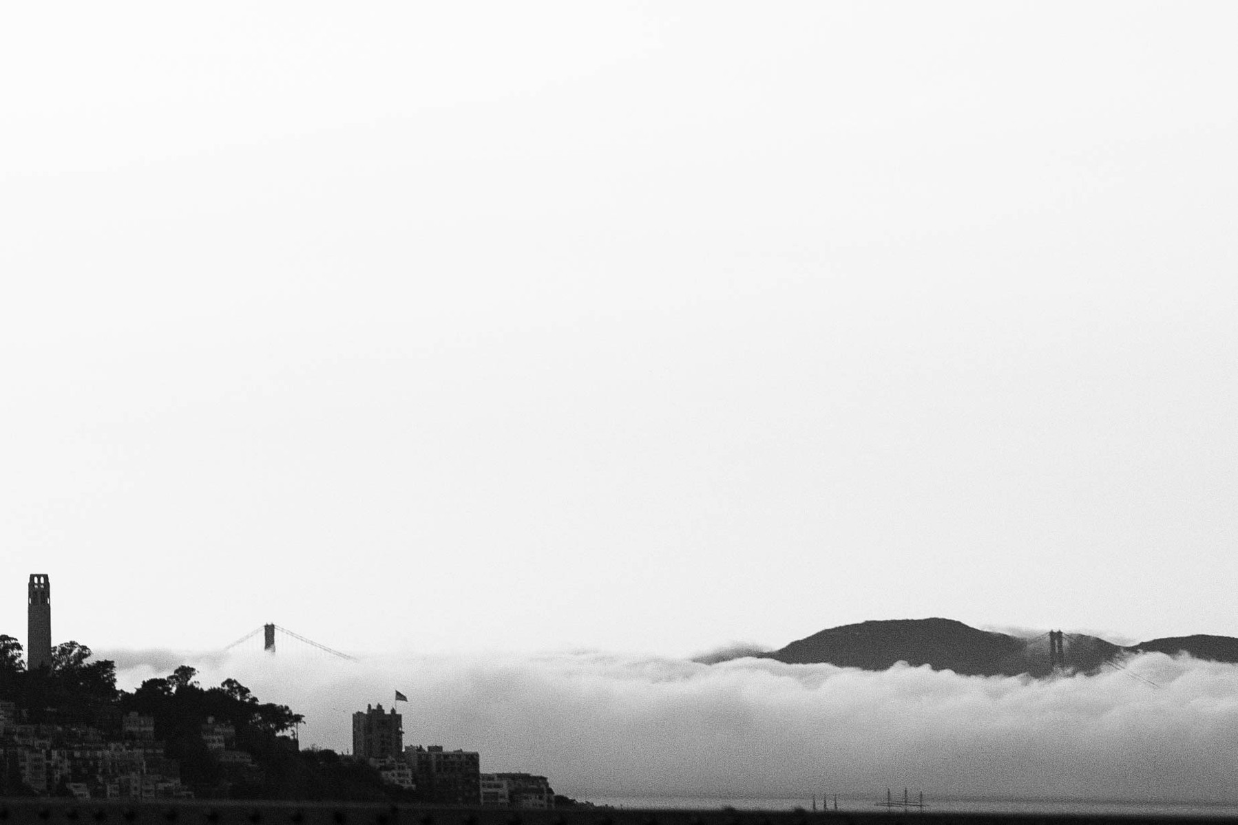 Black and white image of Golden Gate Bridge with fog.