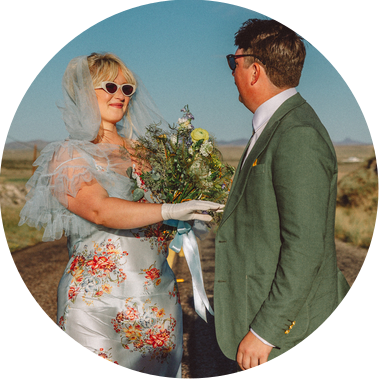 Couple in wedding attire on a road.