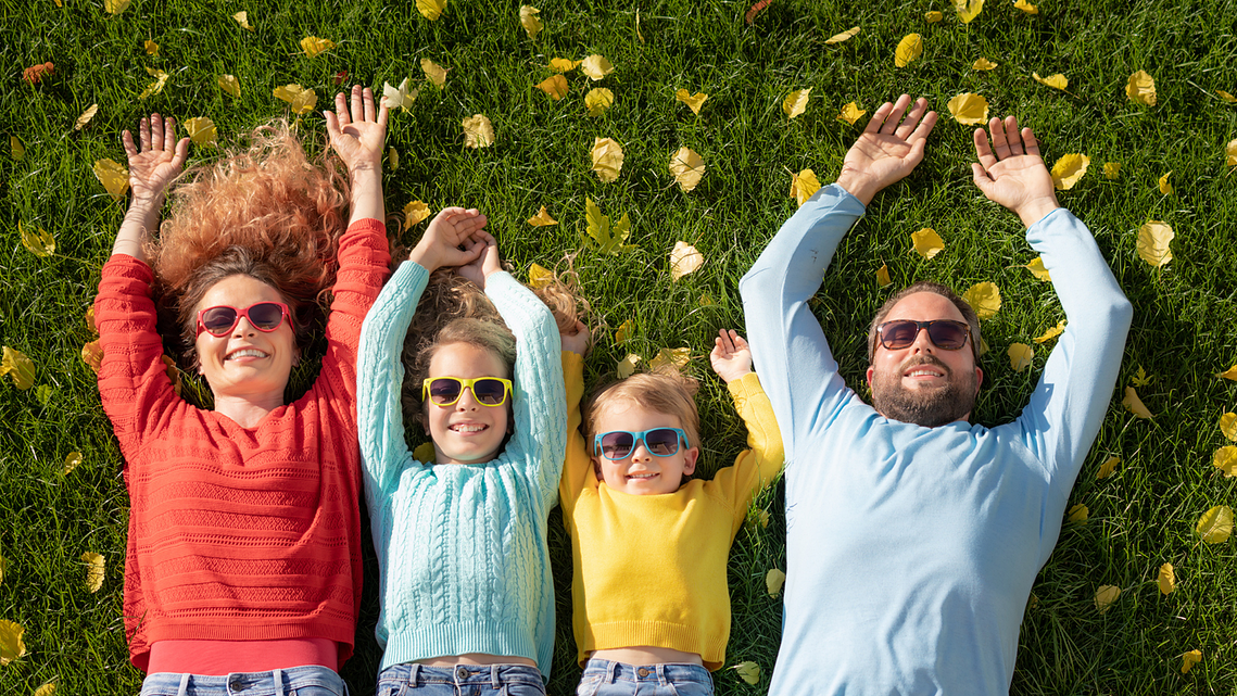 Family shooting session outside, laid down on grass from top angle by Radu Florin