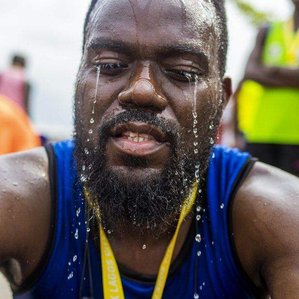 Marathon runner after the run in Lagos pours some water to cool his head.
