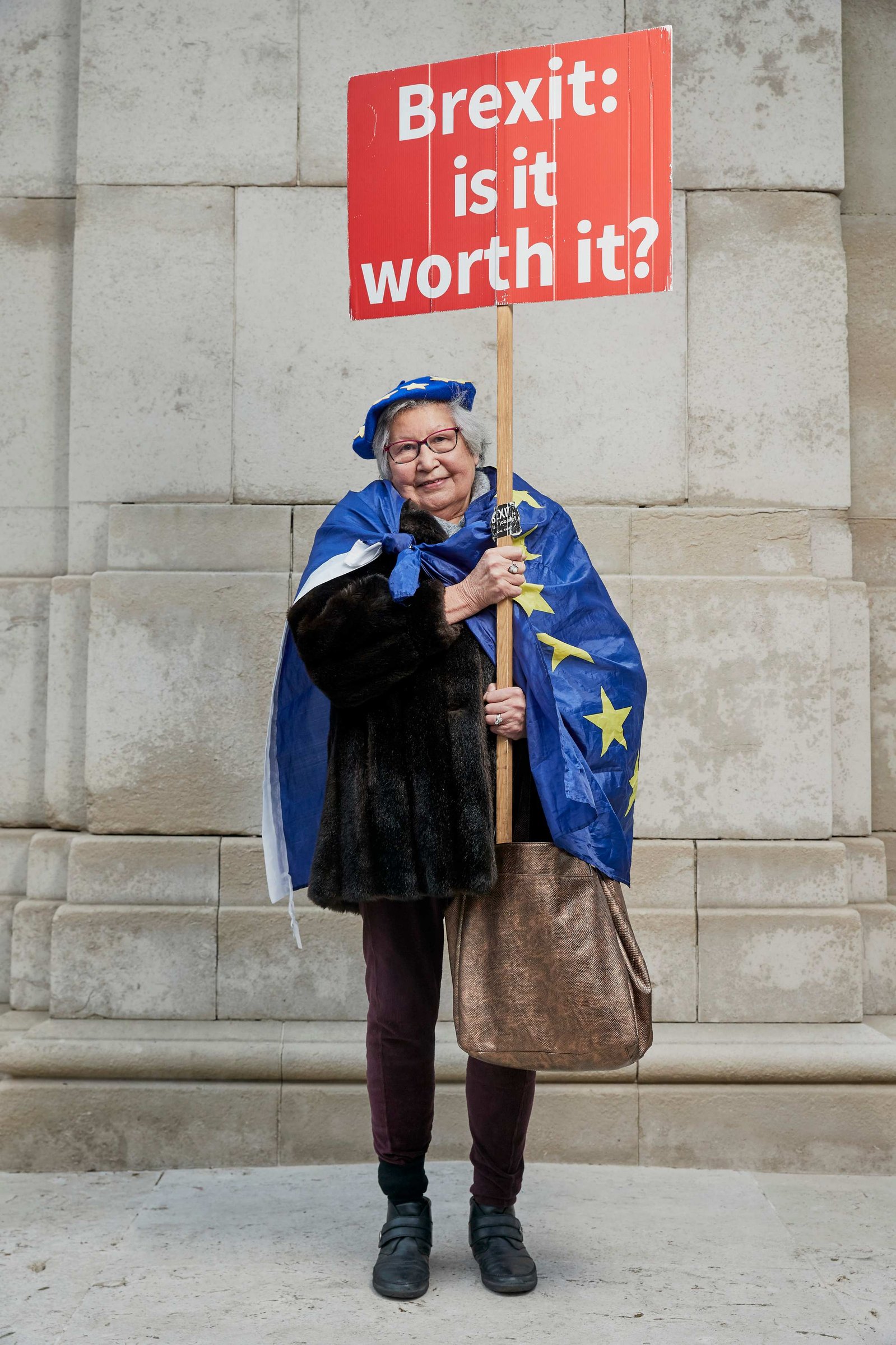 A portrait of Judith Spencer, a Remainer, pro European, and anti Brexit protestor photographed dressed in a blue European Flag holding an anti Brexit placard outside the Houses of Parliament in Westminster, London.