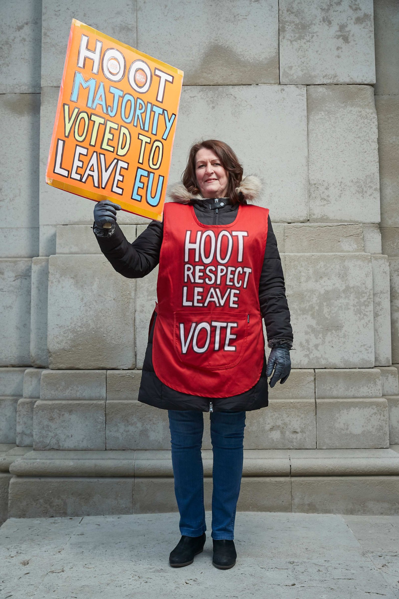 A portrait of Michelle Megan, a leaver and strong Brexit supporter photographed holding a big pro Brexit placard "we voted for Independence" outside the Houses of Parliament in Westminster, London.