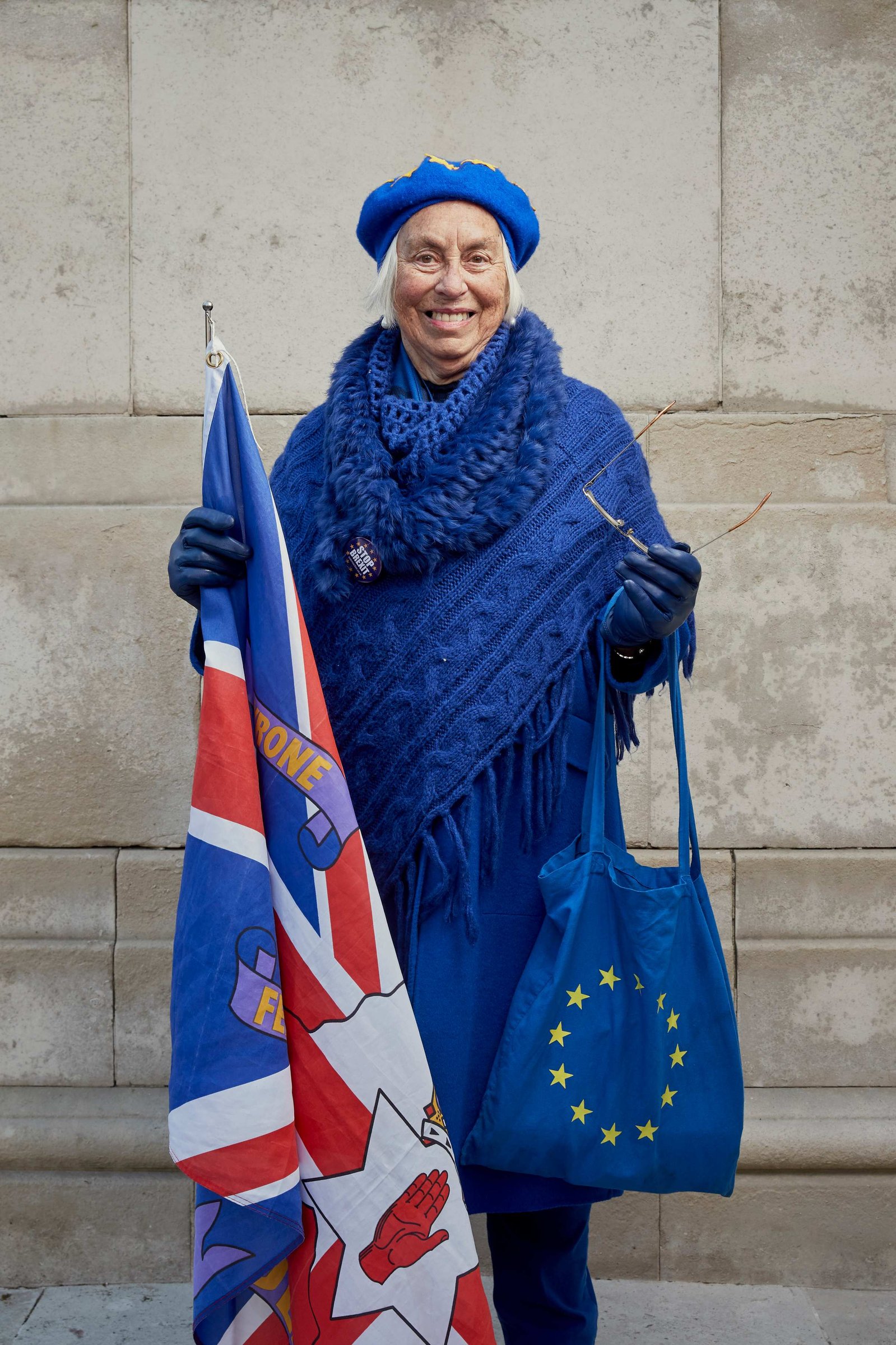 A portrait of Lynne Hall a Remainer, pro European, and anti Brexit protestor photographed dressed in all blue and European handbag with a Union flag outside the Houses of Parliament in Westminster, London.