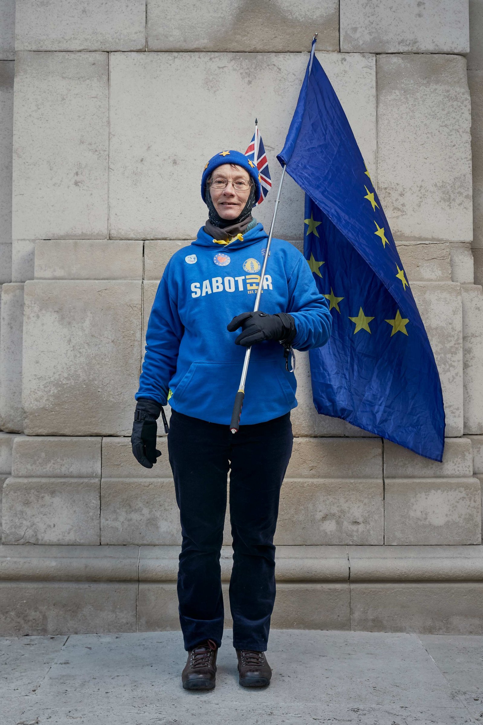 A portrait of Ruth Fryer, a Remainer, pro European, and anti Brexit protestor photographed holding a large European flag outside the Houses of Parliament in Westminster, London.
