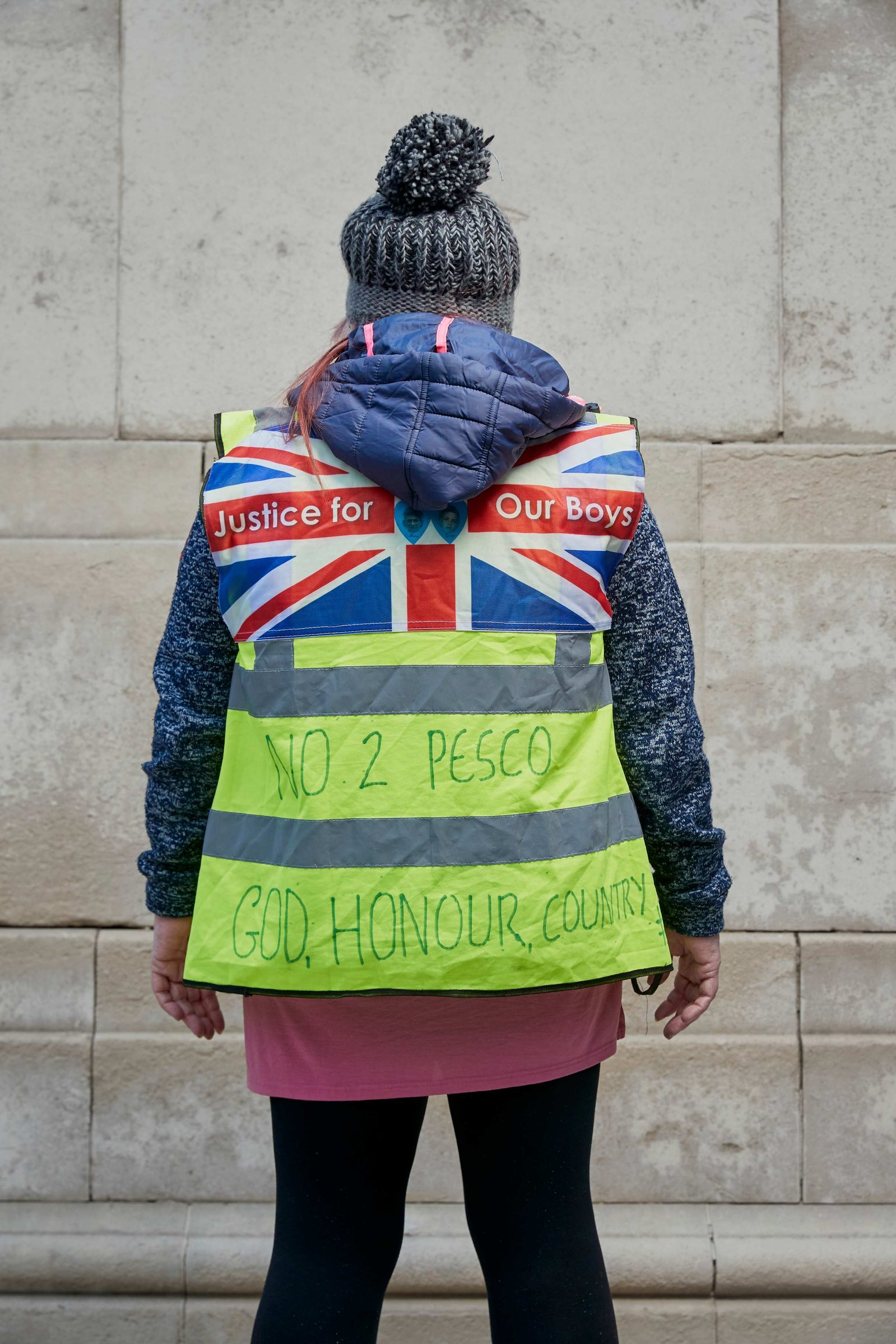 A portrait of the back of Tracy Blackwell, a leaver, strong Brexit supporter and British Gilet Jaune photographed wearing a yellow vest outside the Houses of Parliament in Westminster, London.