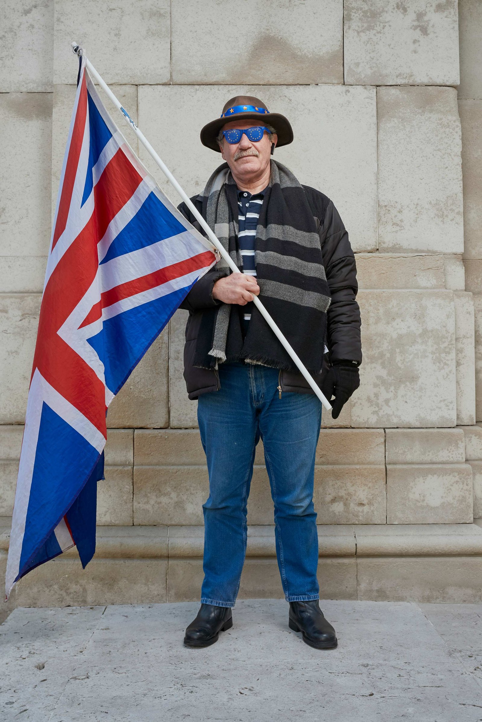 A portrait of Andy Wallis, a Remainer, pro European, and anti Brexit protestor photographed holding a union flag outside the Houses of Parliament in Westminster, London.