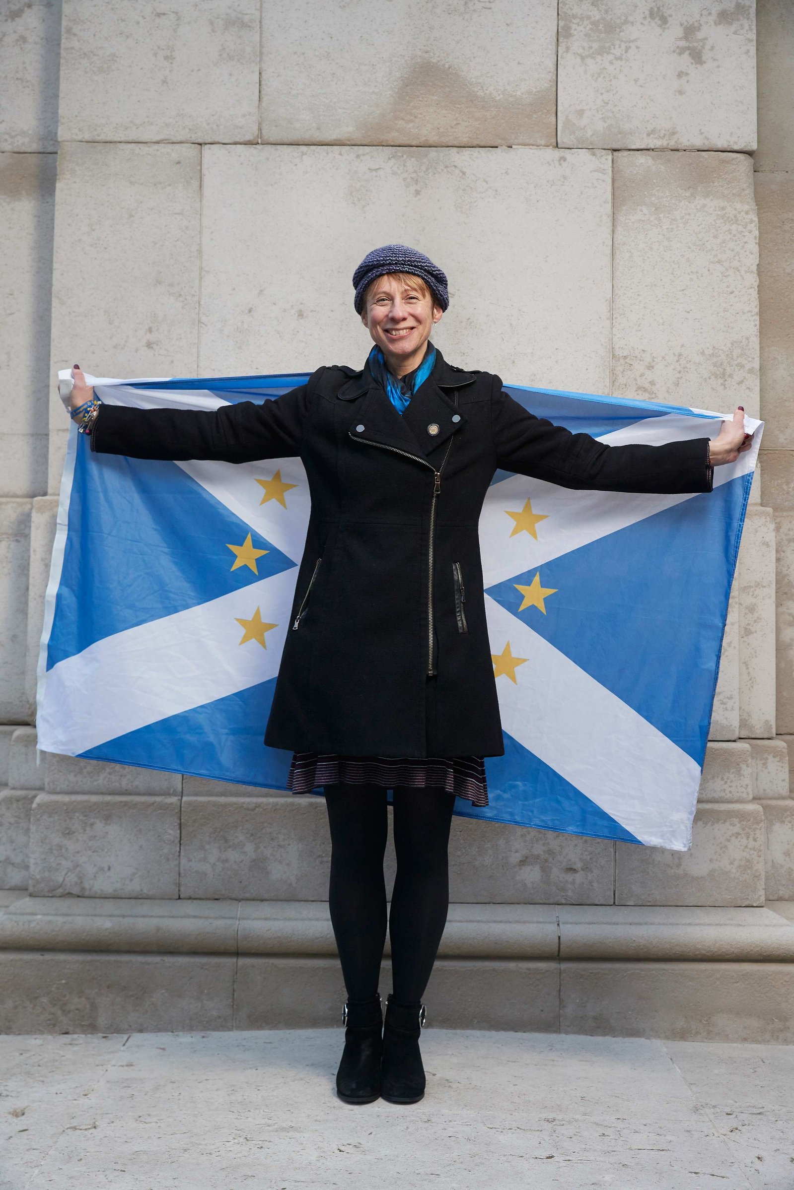 A portrait of Beth Cameron, a Remainer, pro European, and anti Brexit protestor photographed holding a Scottish flag with European stars on outside the Houses of Parliament in Westminster, London.