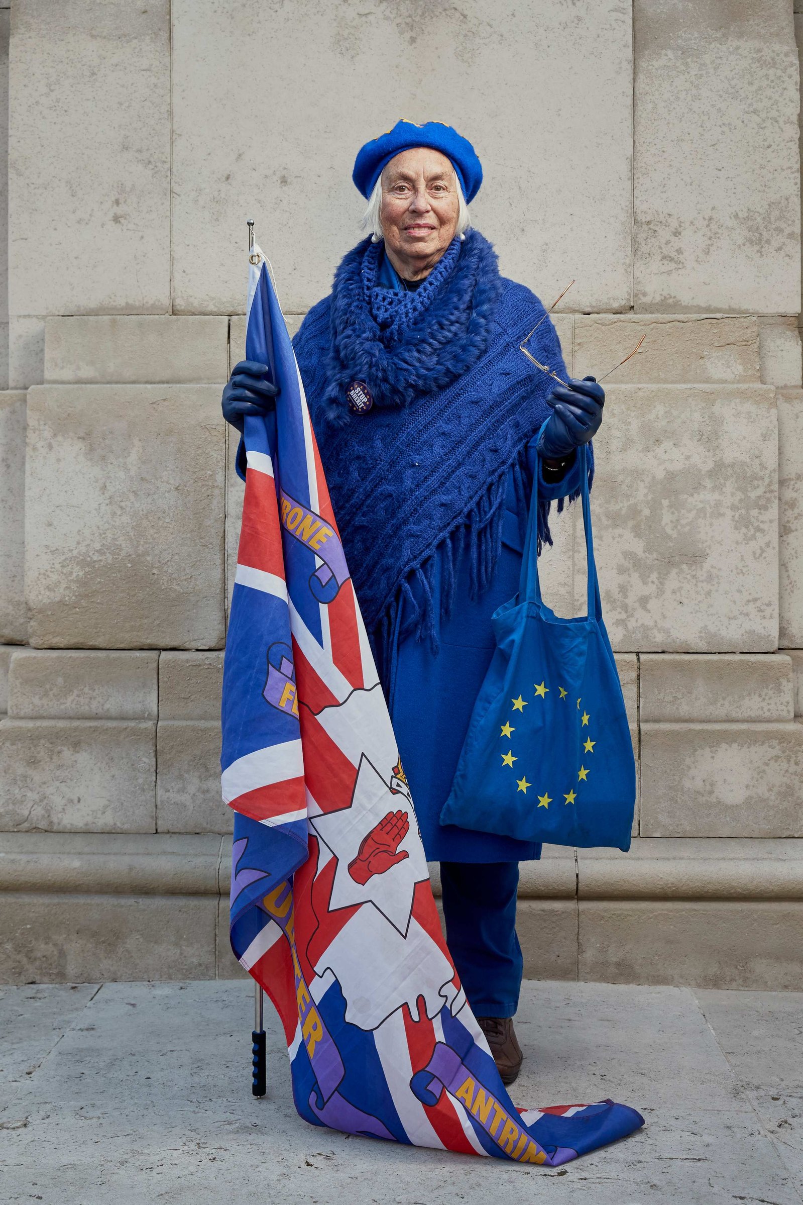 A portrait of Lynne Hall a Remainer, pro European, and anti Brexit protestor photographed dressed in all blue and European handbag with a Union flag outside the Houses of Parliament in Westminster, London.