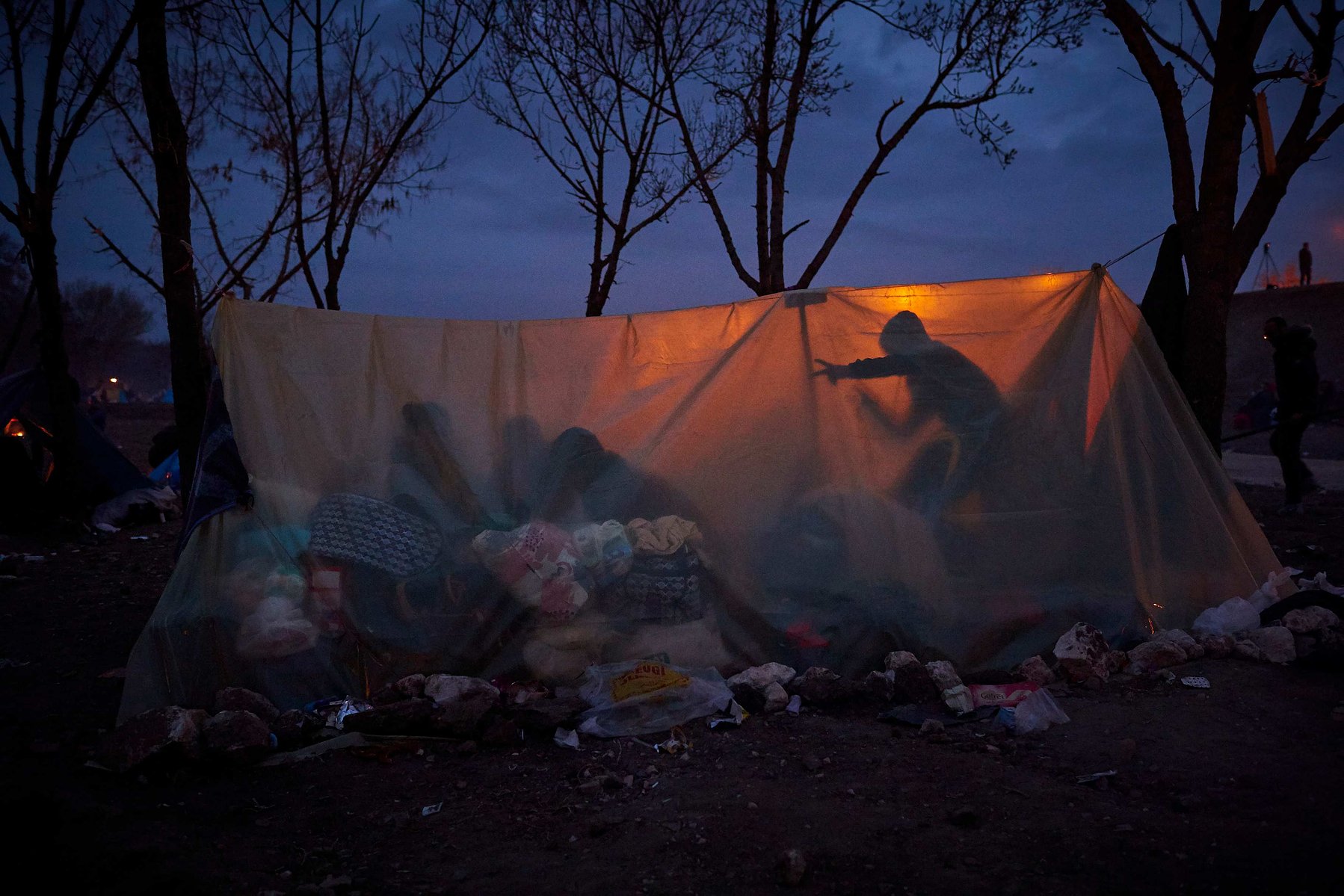 MARCH 5, 2020 - EDIRNE, TURKEY: Refugees take shelter in a makeshift tent as night falls on the banks near Edirne Old Bridge as they wait to cross into Greece and the European Union on March 05, 2020 in Edirne, Turkey.