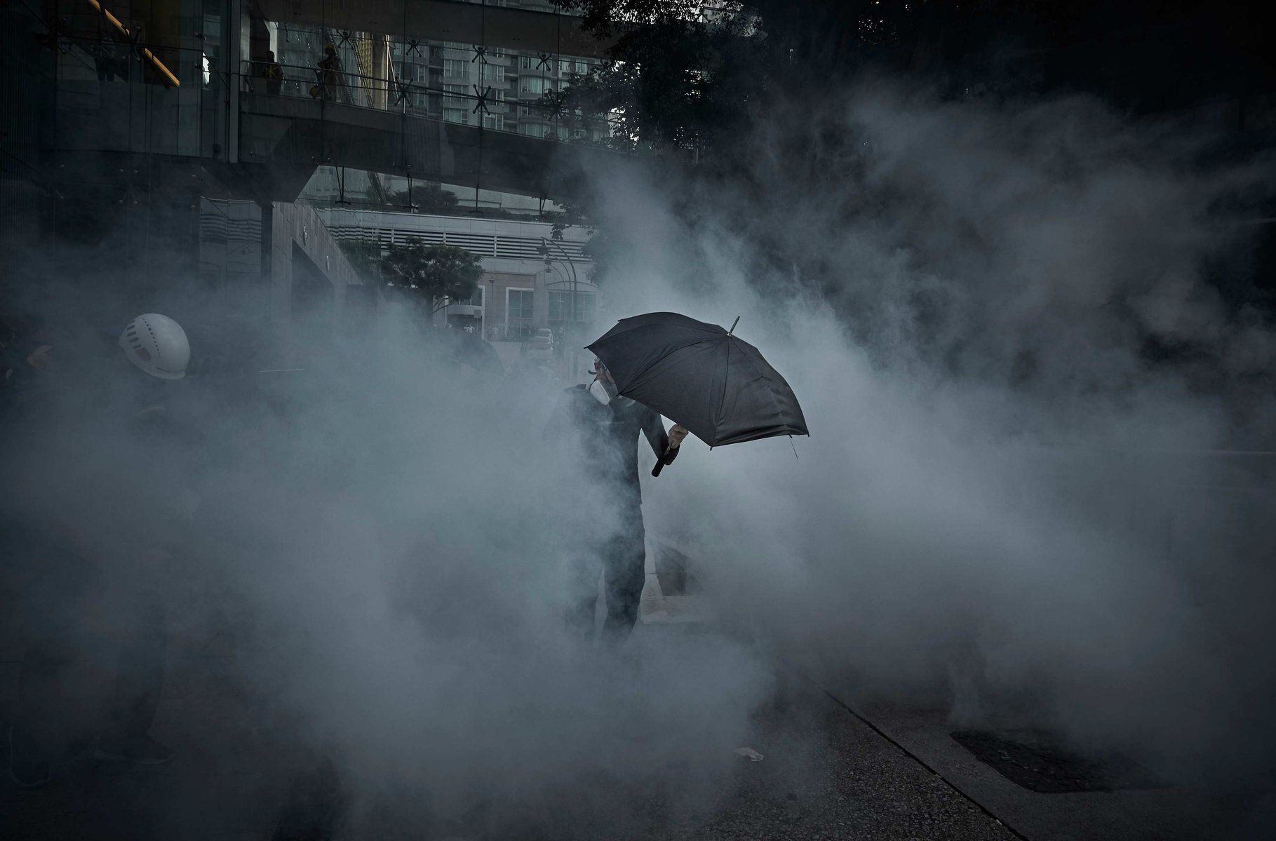 OCTOBER 1: A Pro-democracy protestor walks through clouds of tear gas as protests to mark the 70th anniversary of the People's Republic of China turn violent as the city remains on the edge as protest enter their fourth month