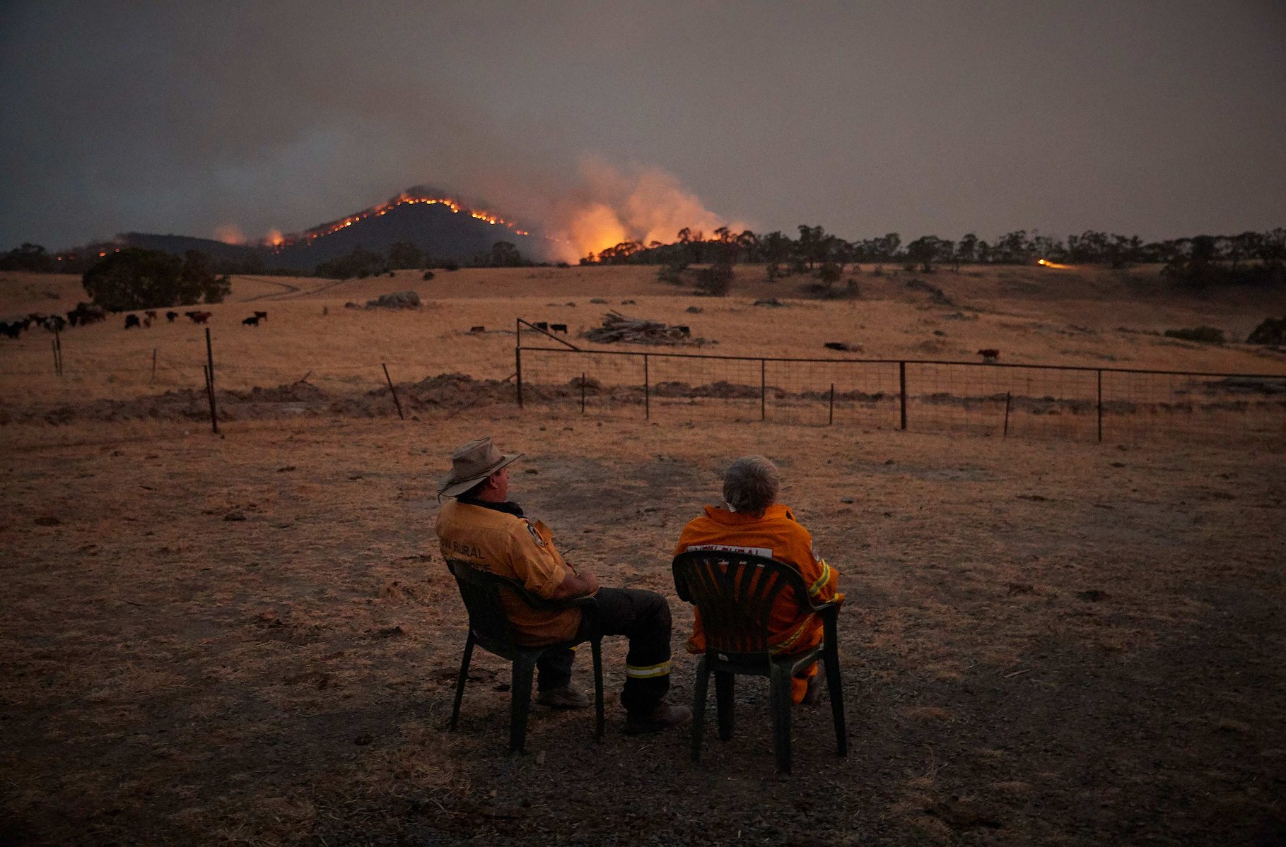 Rural Fire Service, RFS, volunteer firefighters watch as the New South Wales 'Mega' fire, which measures 1.5 million acres, approaches the outskirts of the small town of Tumbarumba, NSW, in the Snowy Mountains, on 11 January.