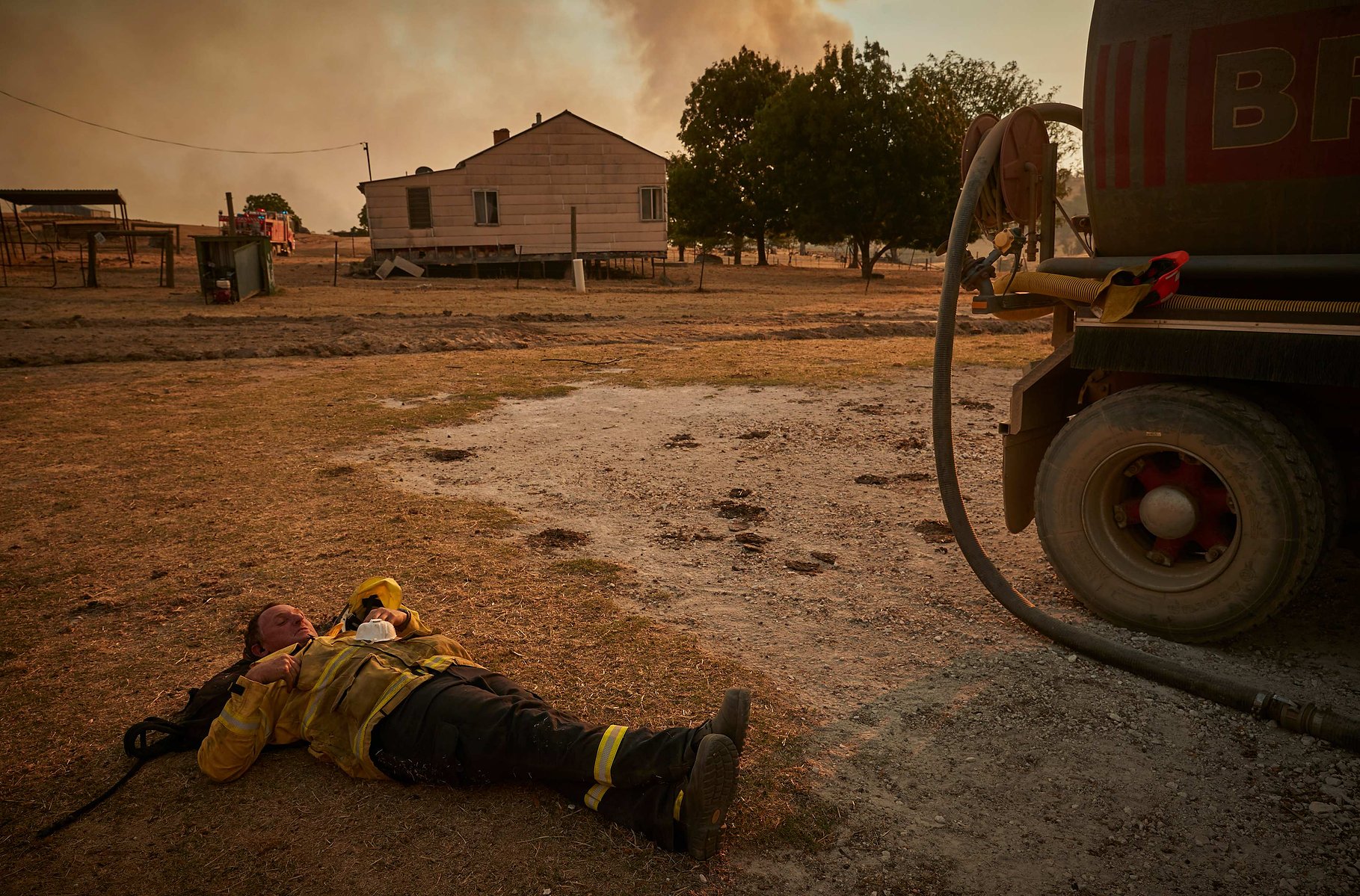 TUMBARUMBA, AUSTRALIA - JANUARY 11, 2020: A Rural Fire Service volunteer firefighter takes a break fighting the 'megafire' on the outskirts of the small town of Tumbarumba in the Snowy Mountains, on 11 January 2019.