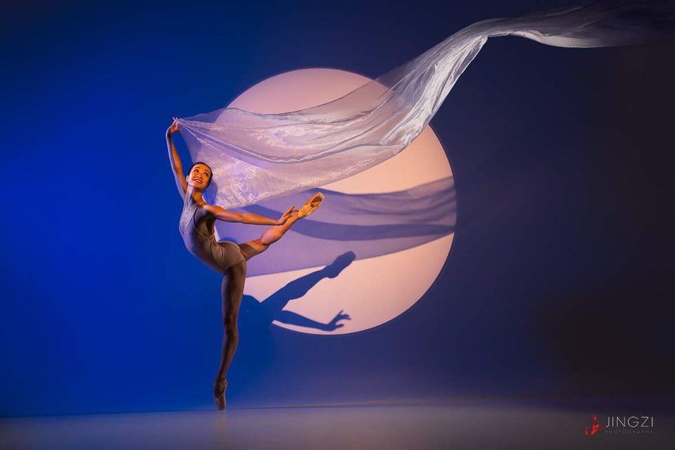 A dance photograph of Xuan Cheng, the principal dancer with Oregon Ballet Theater, dancing with the moon, by award-winning Portland dance photographer Jingzi Zhao.