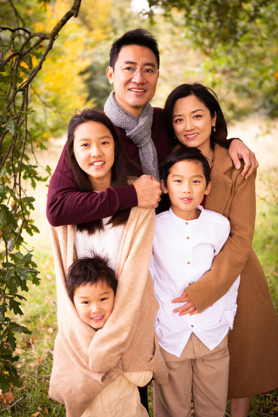 A family of five pose for the camera. A dad with his wife and their teenage daughter and two younger boys.