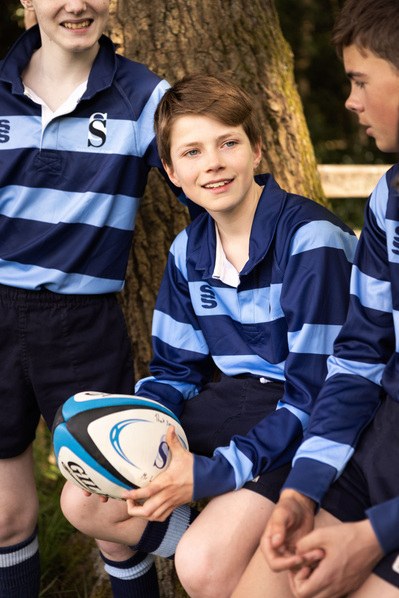 A boy holds a rugby ball in School rugby kit at Sunningdale Prep School, Berkshire