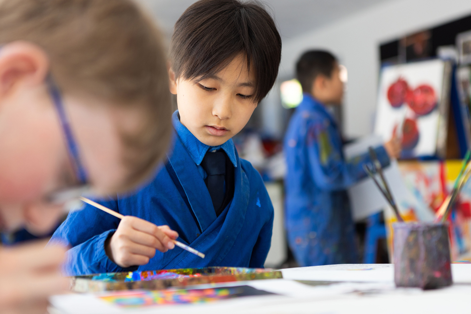 A boy at Sunnindale School, Ascot, Berkshire paints a colourful picture in the art room.