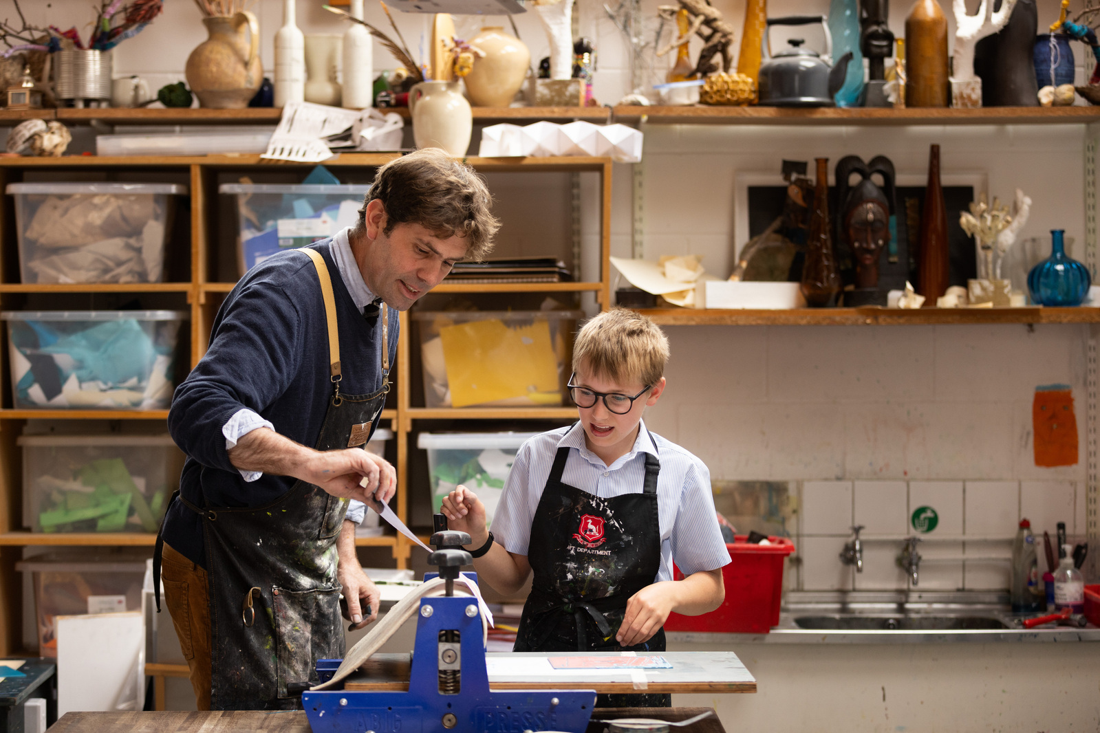 A teacher pulls a lino print off in an art room and shows his student at chafyn grove School, Salisbury, Wiltshire.