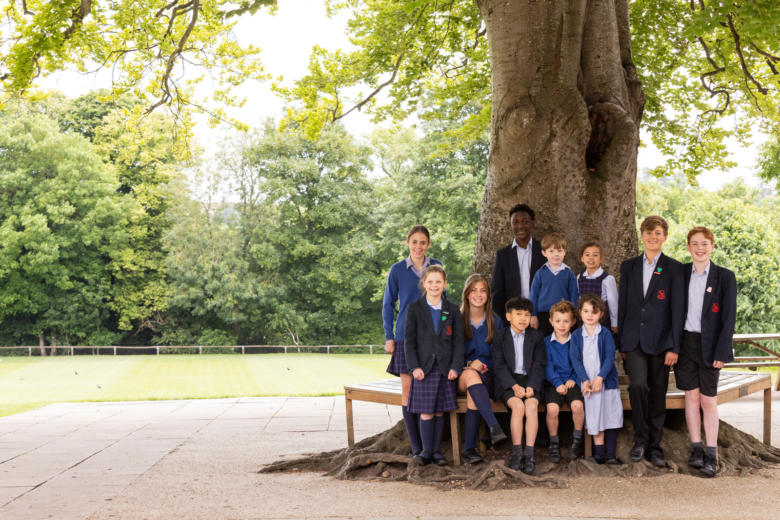 A mixed age group of students at Chafyn Grove School, Salisbury pose in front of a tree