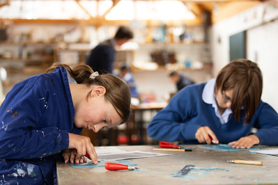 Two students working at lino prints at Chafyn Grove School, Shaftesbury in the art department.