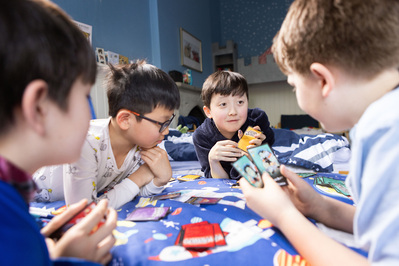 4 boys play cards in their dorm room at Sunningdale, Ascot, Berkshire.