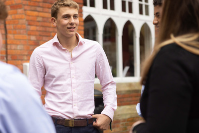 A sixth form student at Clayesmore, Dorset chats to teachers in a pink shirt.