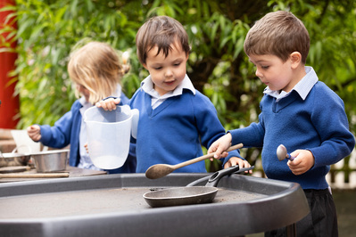 Pre-school students play in a mud kitchen. 3 Chafyn Grove School, Salisbury students play together.