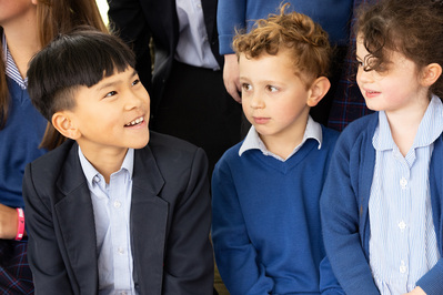 Pupils at Chafyn Grove School, Salisbury in school uniform chat to each other. Three pupils, the oldest wearing a blazer and smiling at the younger two.