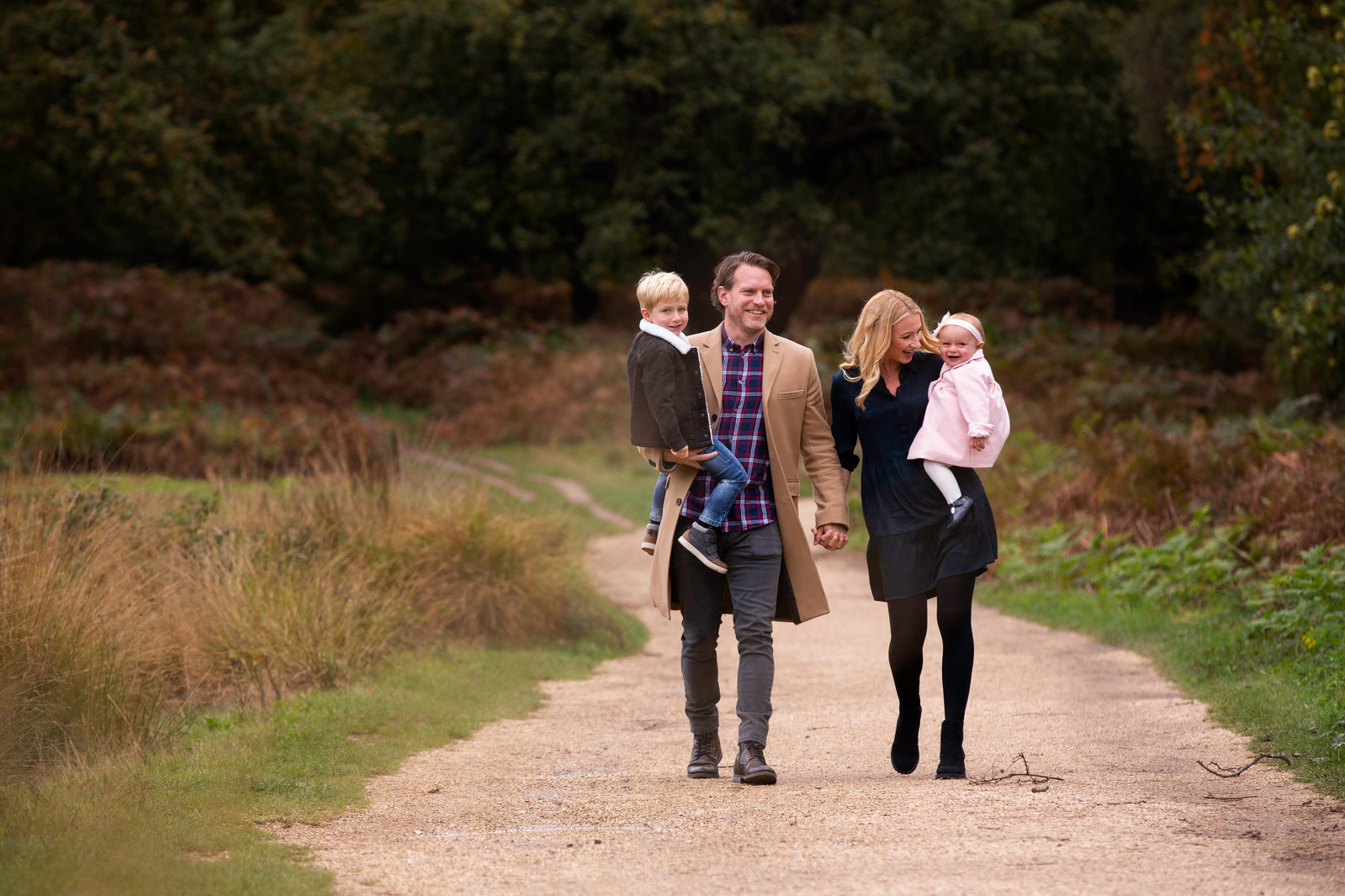 A family of four walking down a road. Photograph taken in North Dorset by professional photographe rAmelia Johnson