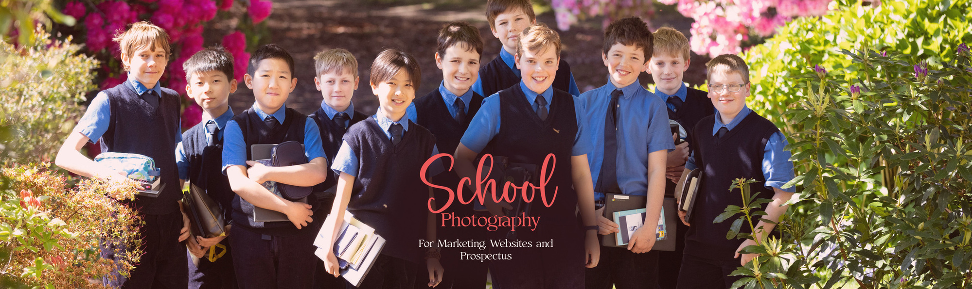 A big group of boys at Sunningdale Prep School, Ascot, Berkshire with chrome books and notebooks pose for a photograph in school uniform.