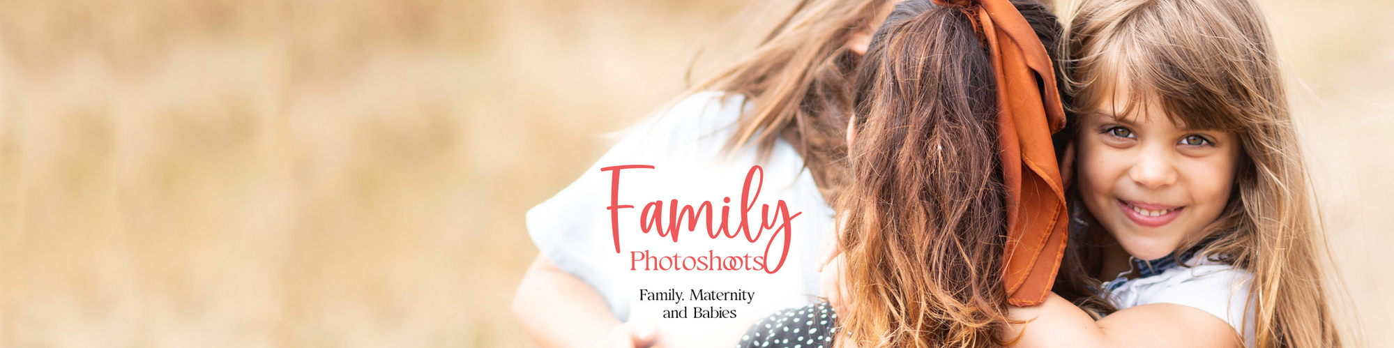 A young girl with brown eyes and long brown hair looks straight at the camera smiling. She is clinging onto her mum and looking over her shoulder. The back of her mother's head shows. She is at the Hengistbury Head Beach, Dorset