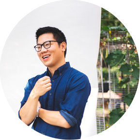 Author Hartley Lin candidly laughing against a classic white backdrop in a Toronto backyard 