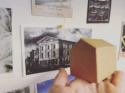 Participants will be able to write and draw their own thoughts on ending racism onto the growing new building. After a layer is filled, a new layer will be added. Cardboard, paper, glue, mixed media. Started may, 2022. 