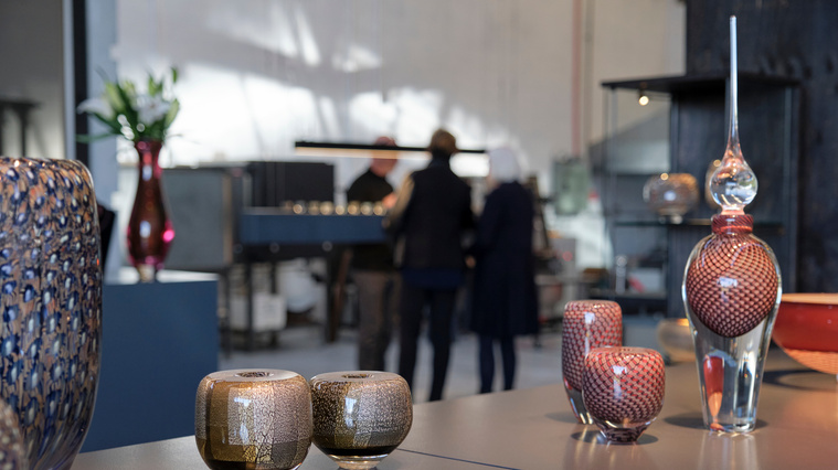 Photograph of Goldfields and Caneworks vessels on bench in the Glass Manifesto Gallery and Studio, looking across to the kilns in the background. 