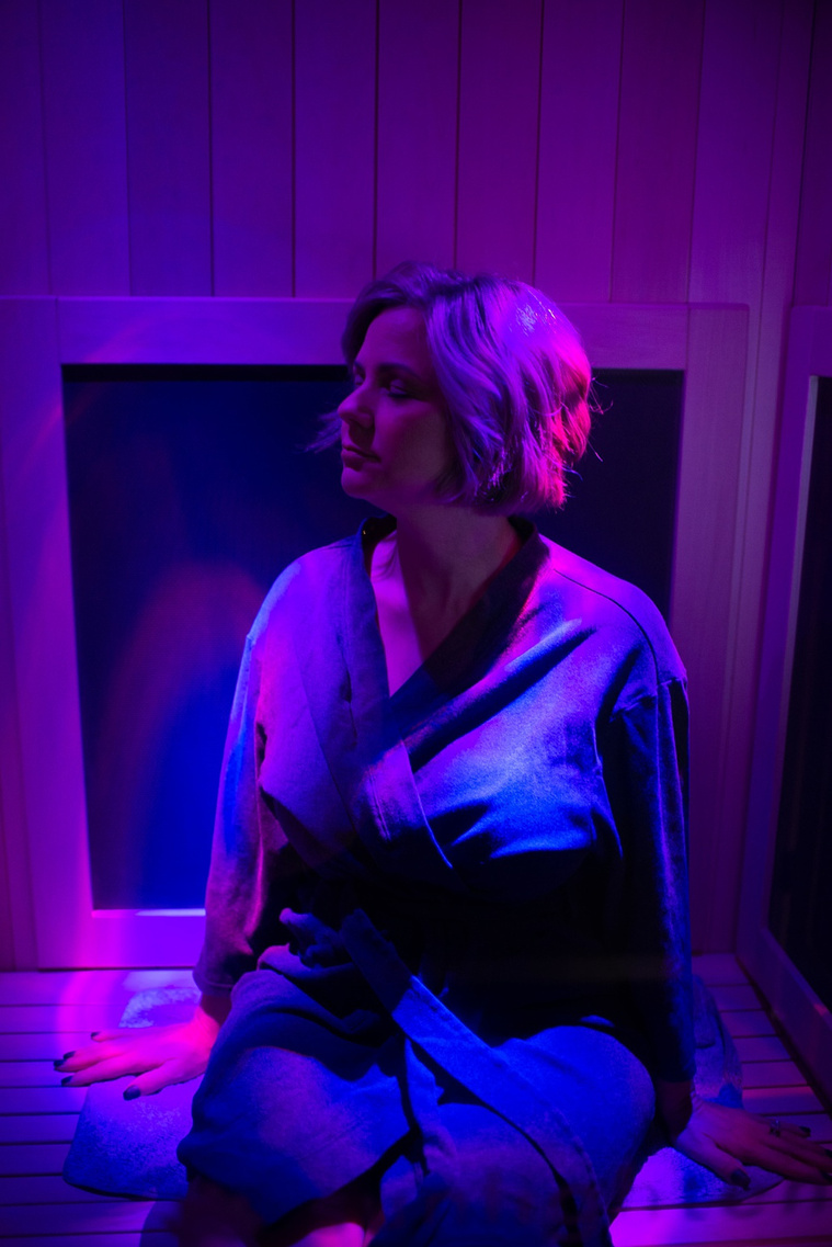 business owner inside an infrared sauna with purple lights at a branding session at Vibe Beauty Bar in Tuttle, Oklahoma