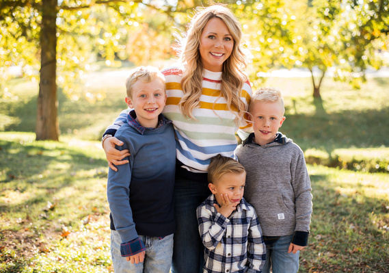 a mom hugs together with her three young sons at Will Rogers Park in Oklahoma City, Oklahoma at a fall photo mini session by Cheryl Jackson Photography