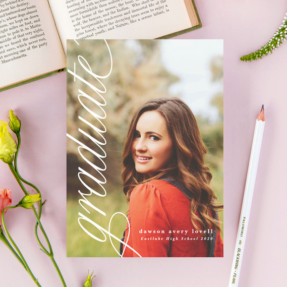 photo of a custom grad announcement card with a high school girl's senior photo surrounded by a pink background, a book and flowers