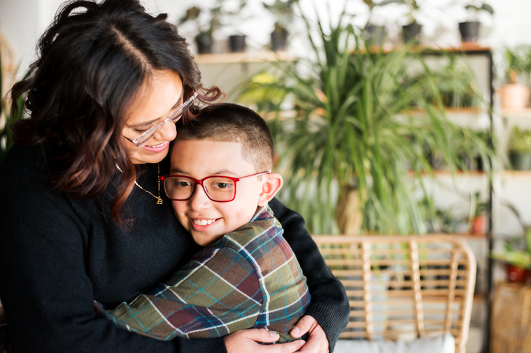 a mom and son hug each other and smile at a plant shop in Oklahoma City Oklahoma