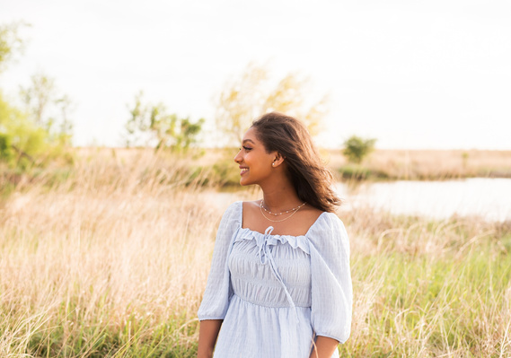 Senior girl poses in a grassy field in Oklahoma for a photo session