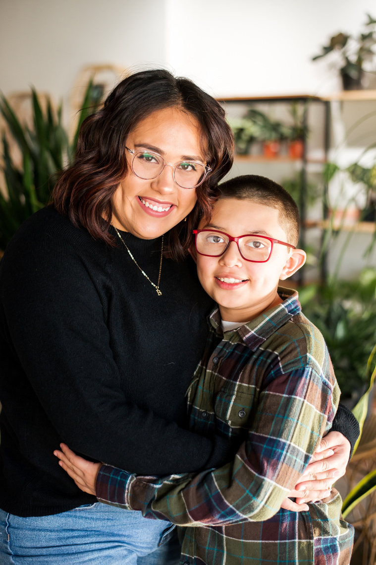 a mom and son hug each other and smile at a plant shop in Oklahoma City Oklahoma