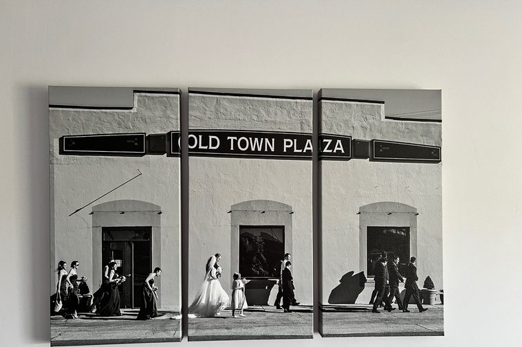 photo of a 3 piece canvas wall art triptych hanging on the wall with a wide angle black and white image of a wedding party