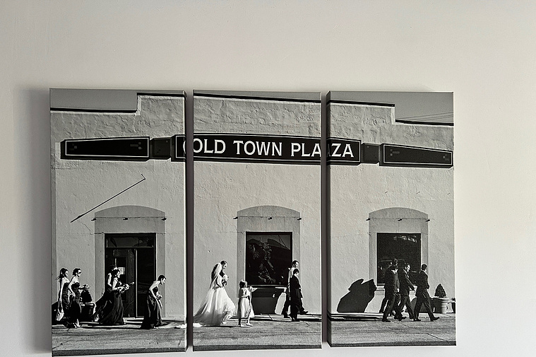photo of a 3 piece canvas wall art triptych hanging on the wall with a wide angle black and white image of a wedding party