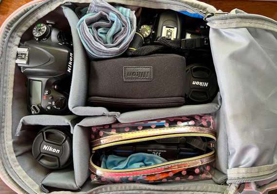 Photo taken from directly above of the contents inside a senior portrait photographer's camera bag including camera bodies, lenses, flash and other items
