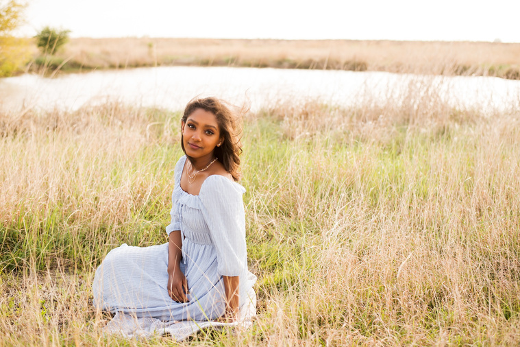 Senior girl poses in a grassy field in Oklahoma for a country photo session