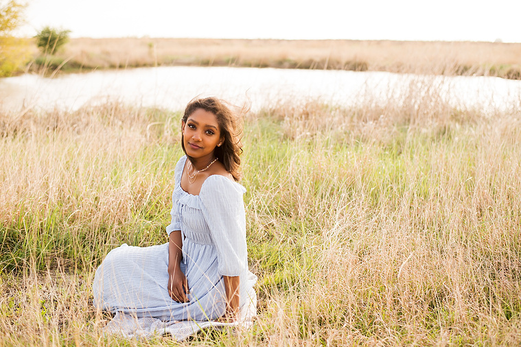 Senior girl poses in a grassy field in Oklahoma for a country photo session